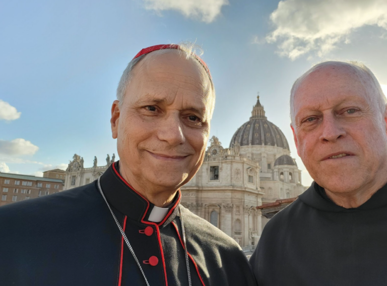 Father Art Purcaro (right, in black) stands beside Pope Leo XIV when he was still a cardinal (in black and red on the left) in St. Peter's Square.